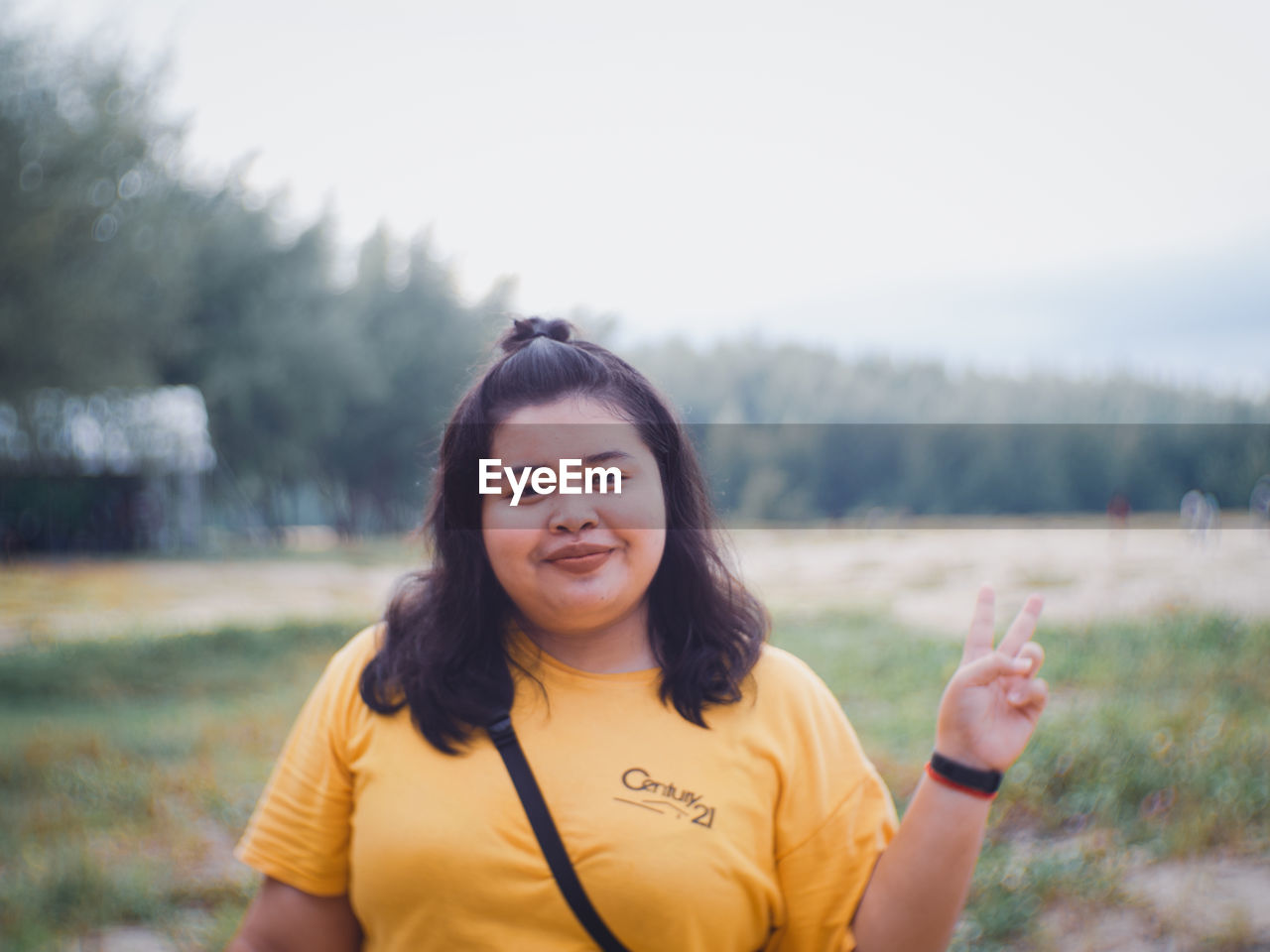 PORTRAIT OF HAPPY WOMAN STANDING ON FIELD