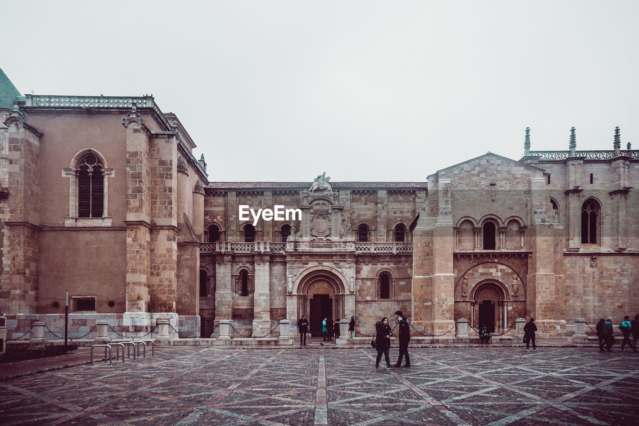 GROUP OF PEOPLE IN FRONT OF HISTORIC BUILDING