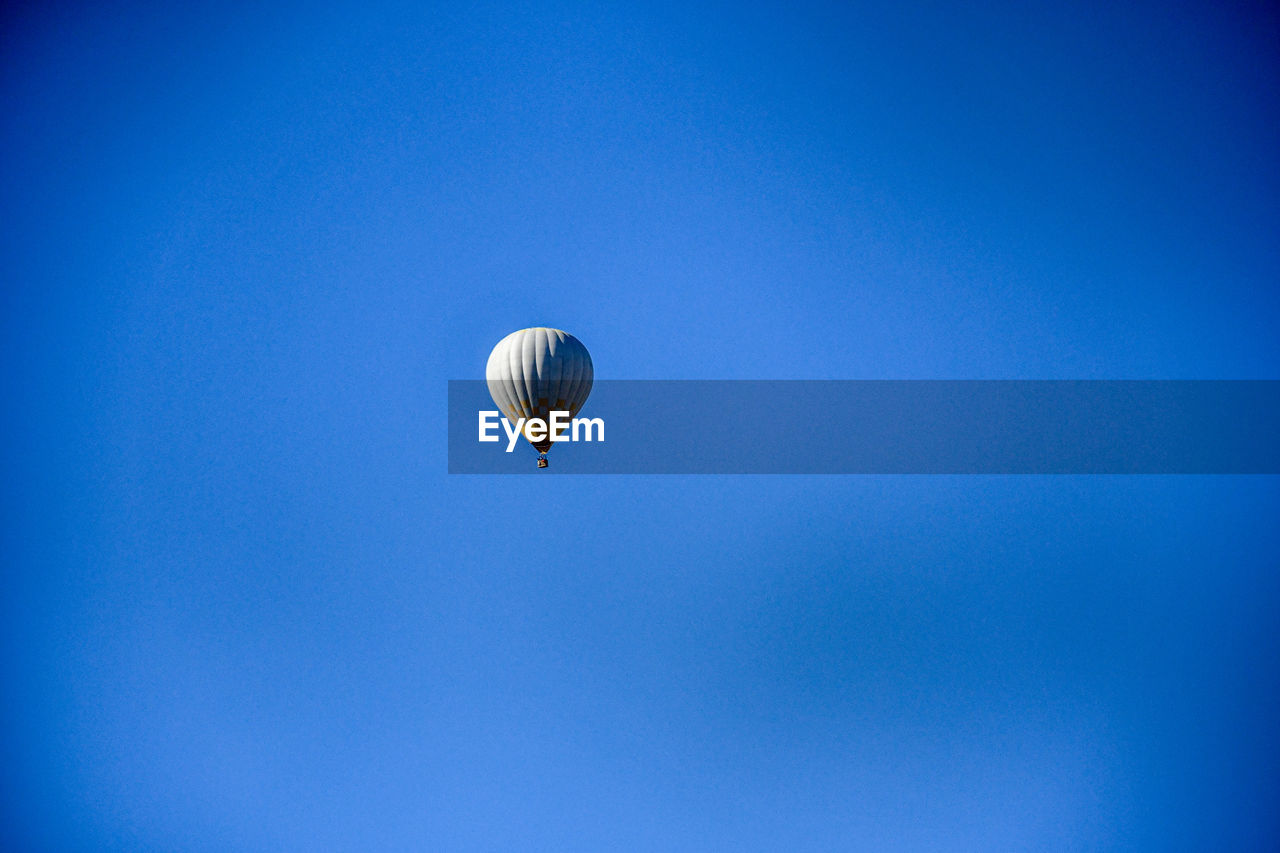 LOW ANGLE VIEW OF HOT AIR BALLOON IN BLUE SKY