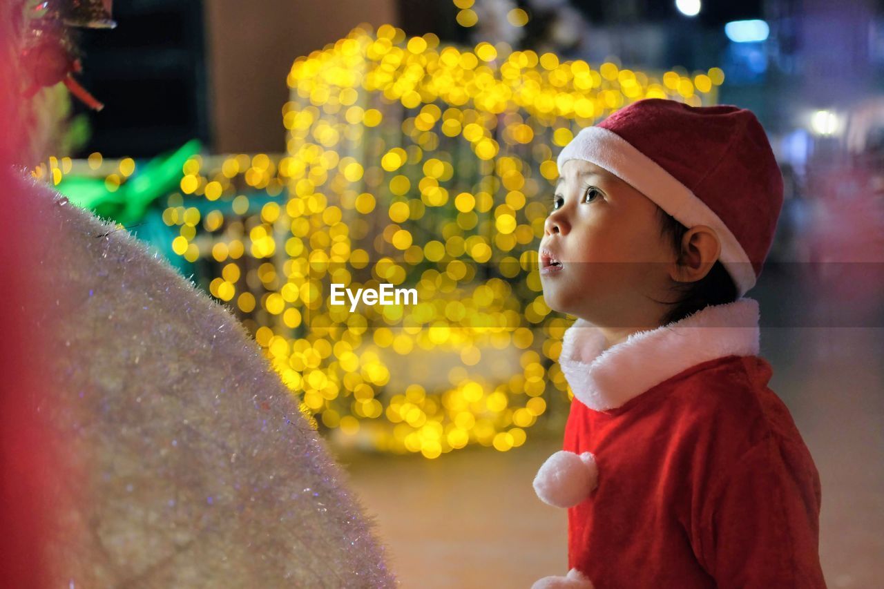 Side view of a young woman wearing a santa suit looking away 