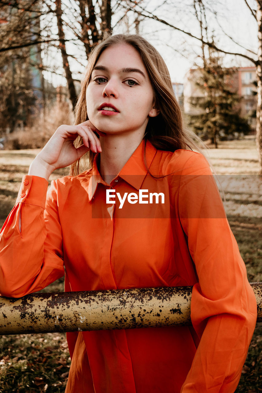 PORTRAIT OF BEAUTIFUL WOMAN STANDING AGAINST TREE