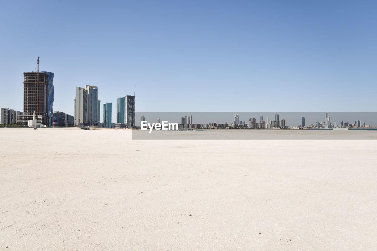 Manama skyline with skyscrapers and desert sand beach in kingdom of bahrain 