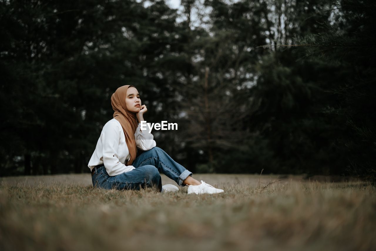 Full length of woman sitting on field