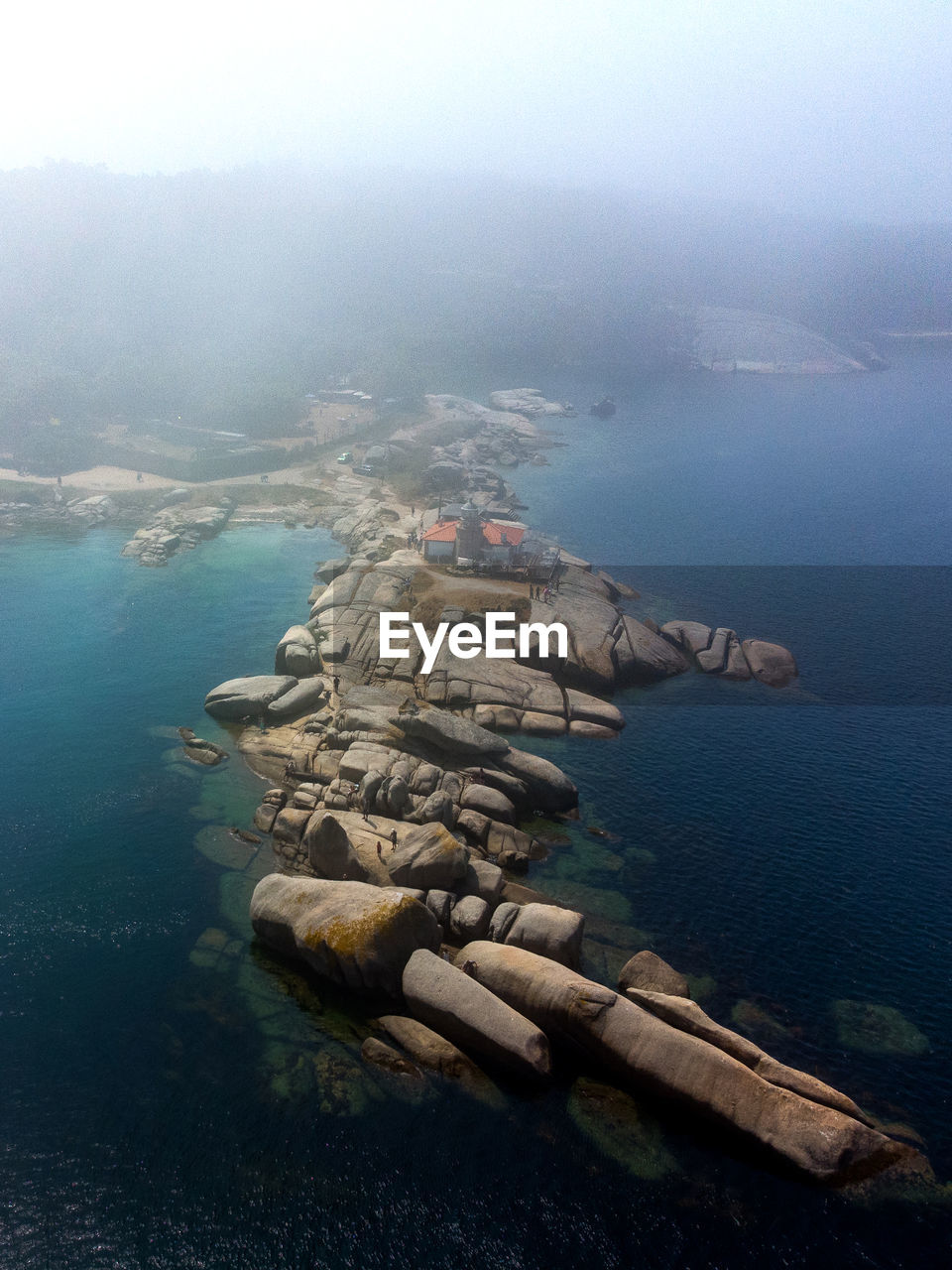 Aerial dron view of punta cabalo lighthouse from the sea in arousa island, spain.