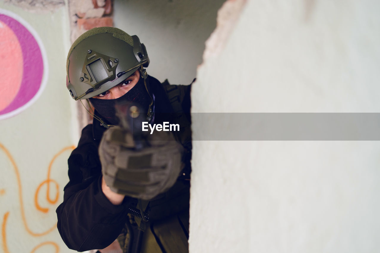 Army soldier aiming gun in building