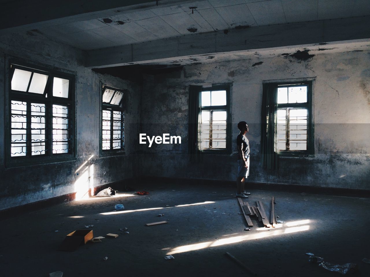 Side view of man standing in abandoned room