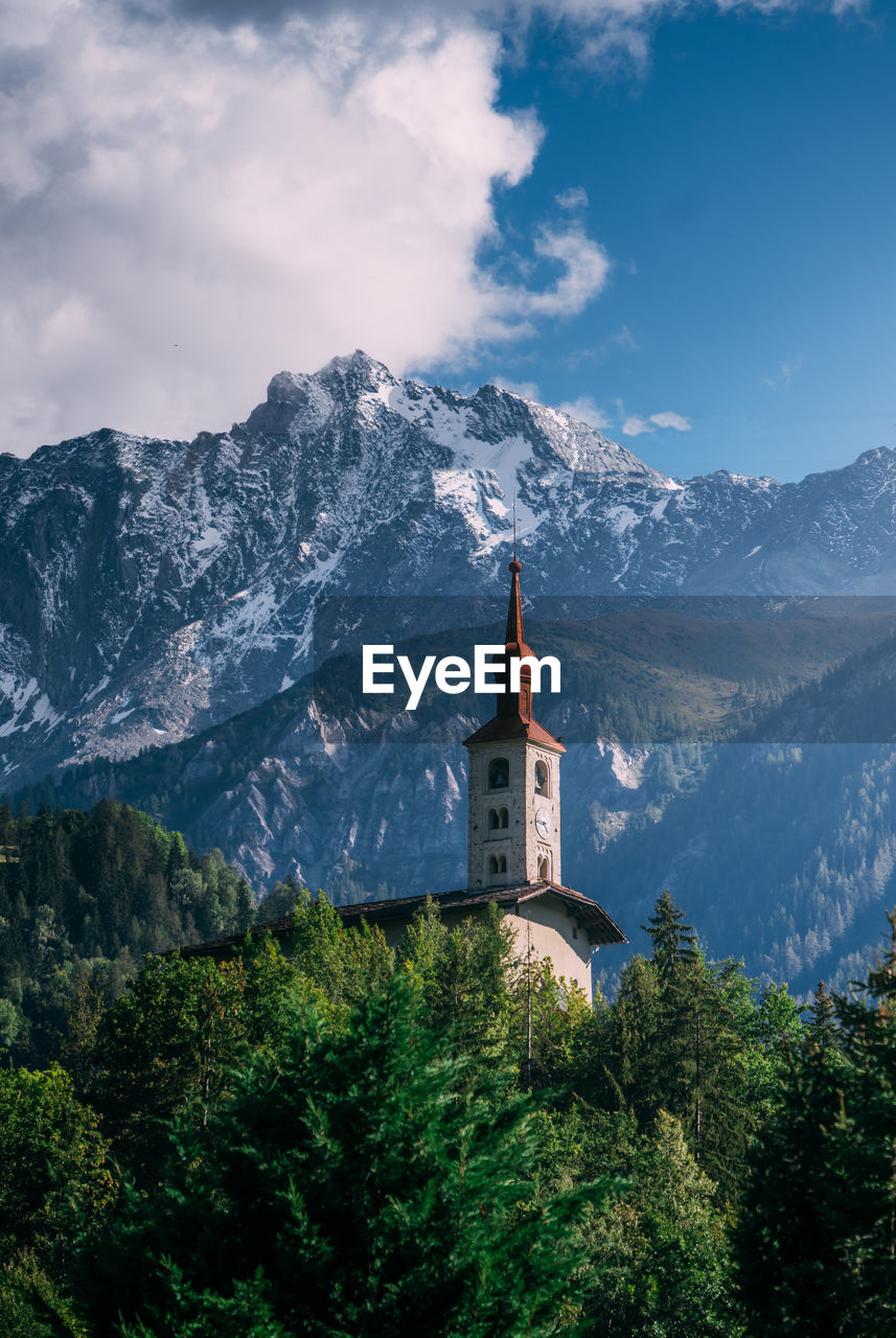Traditional building by mountains against sky