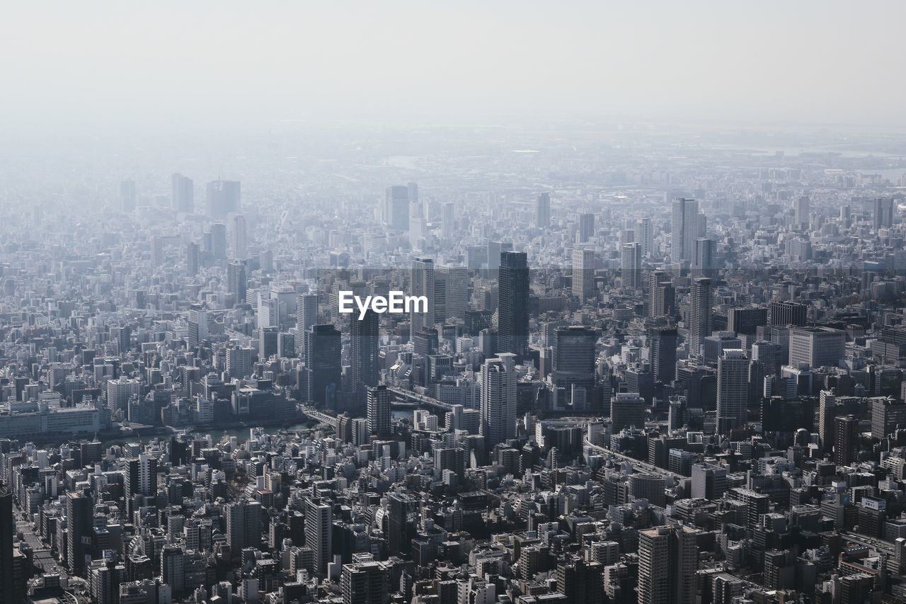 Aerial view of buildings in city against sky