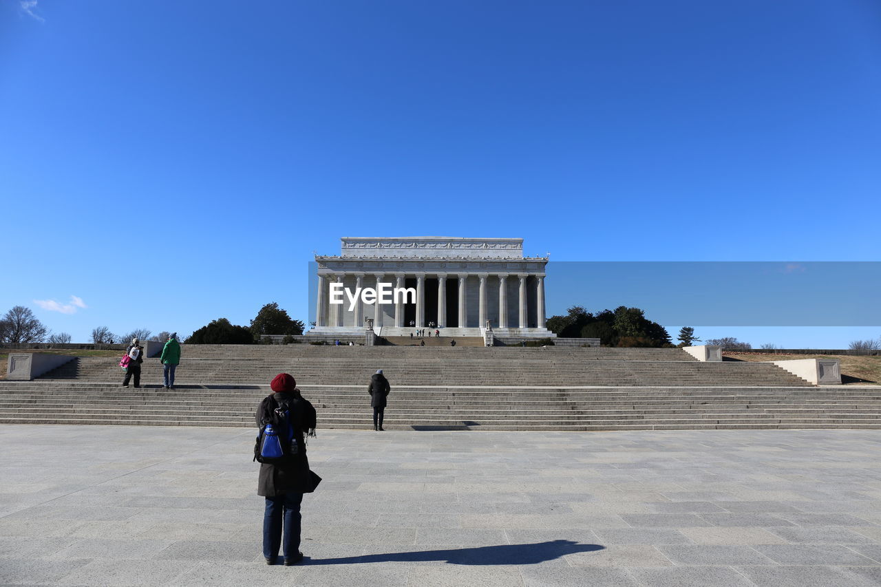 PEOPLE WALKING IN FRONT OF HISTORICAL BUILDING