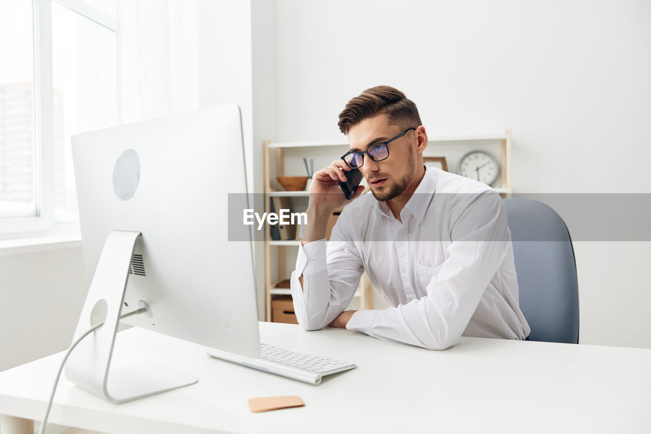 Businessman talking on phone at office