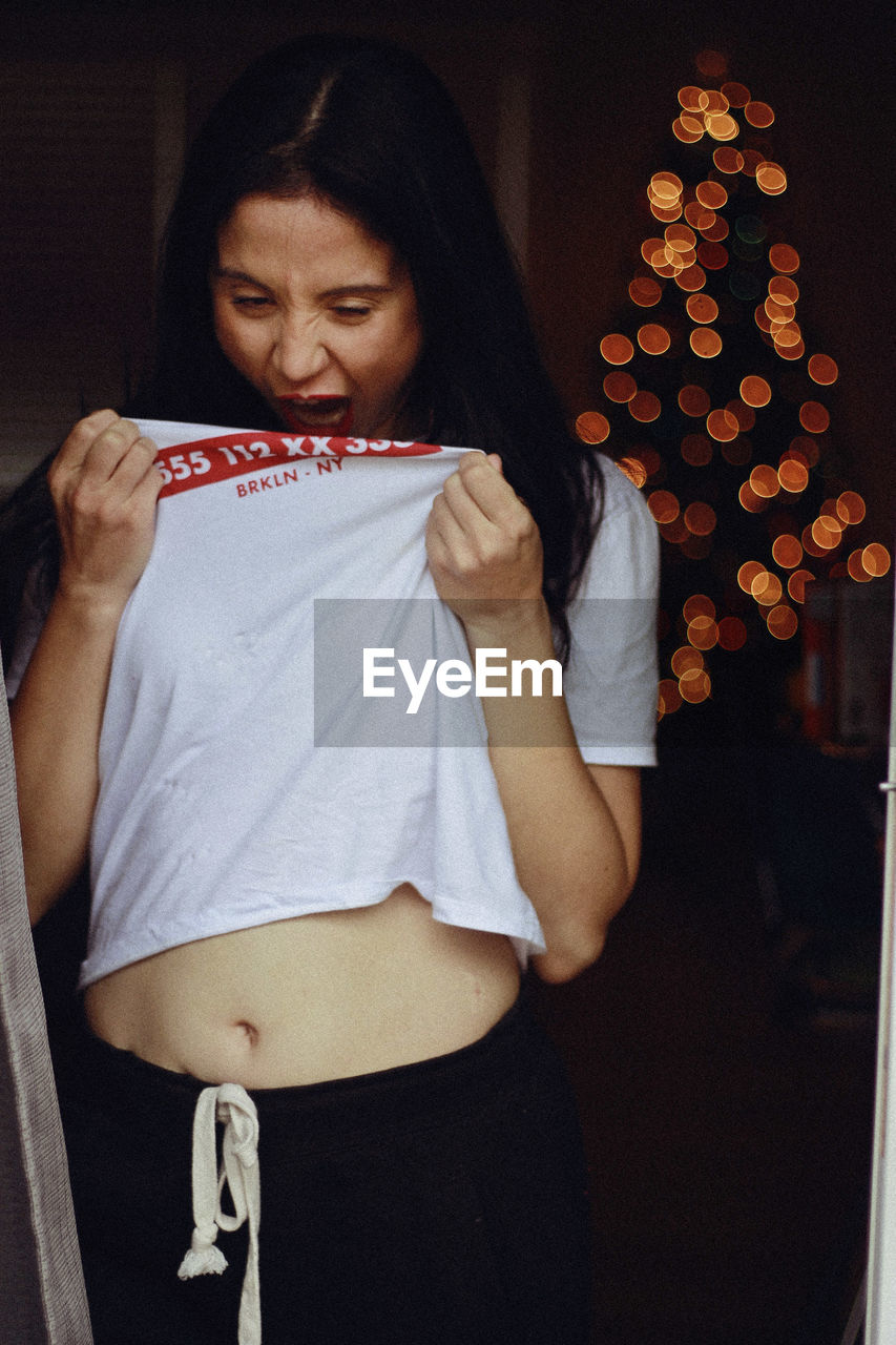 Woman wearing t-shirt while standing at home