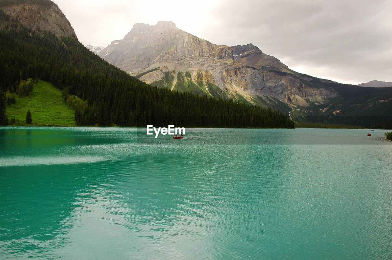 Scenic view of lake by mountains against sky