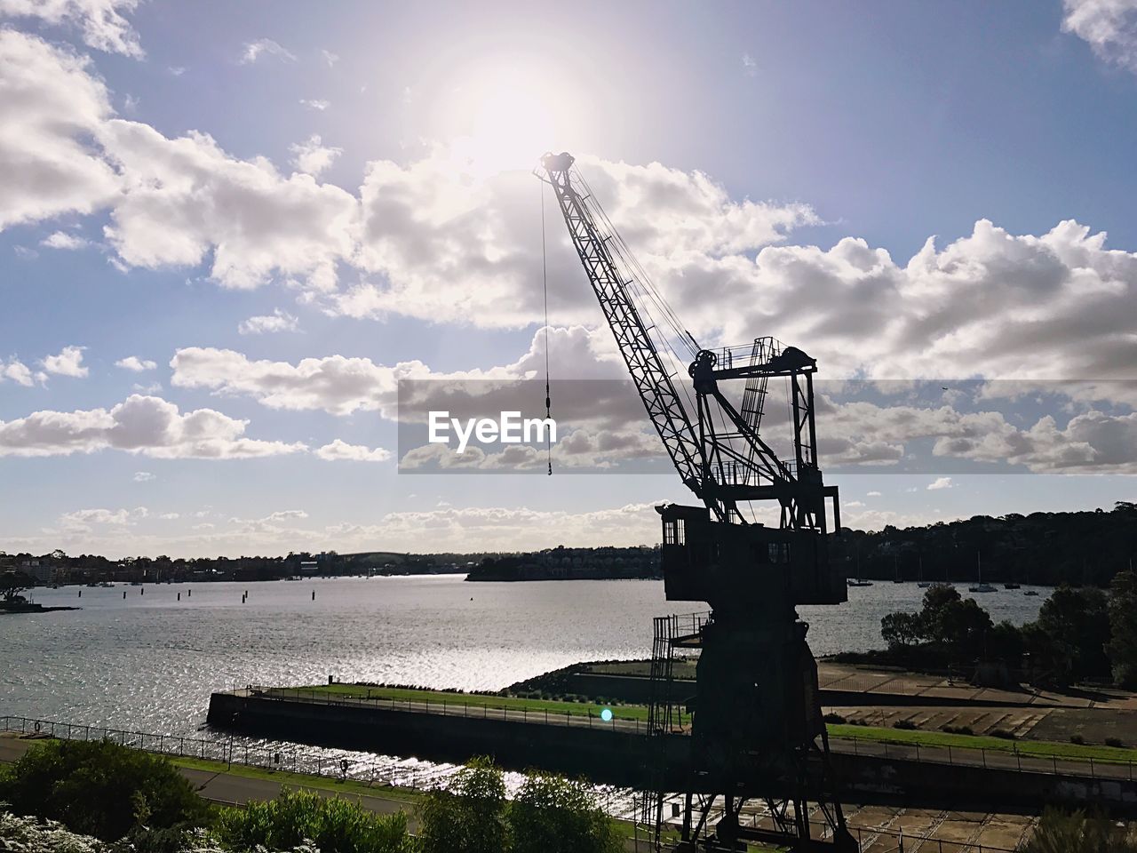 CRANES AGAINST SKY IN WATER