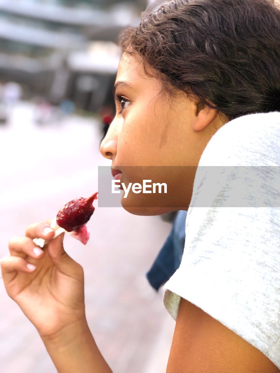Close-up side view of girl eating flavored ice