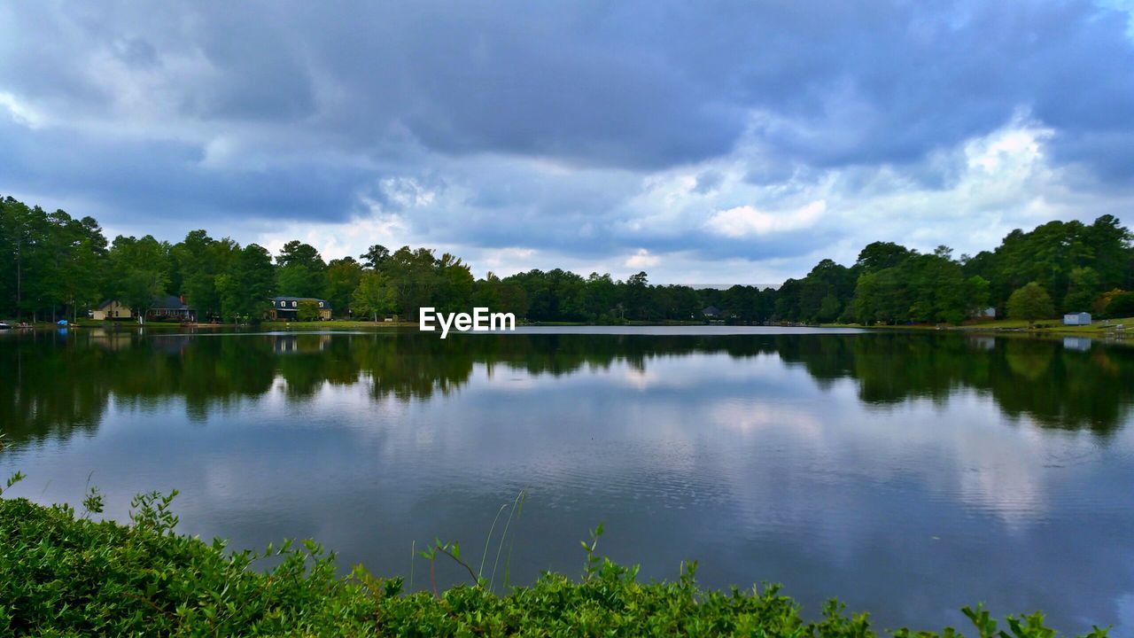 SCENIC SHOT OF CALM COUNTRYSIDE LAKE AGAINST CLOUDS