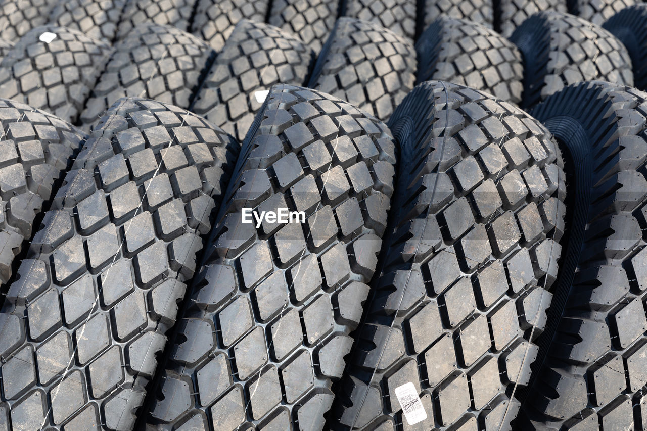 tread, synthetic rubber, automotive tire, tire, no people, backgrounds, wheel, pattern, natural rubber, full frame, rubber, transportation, day, outdoors, automotive exterior, road surface, close-up, in a row, textured, large group of objects, repetition