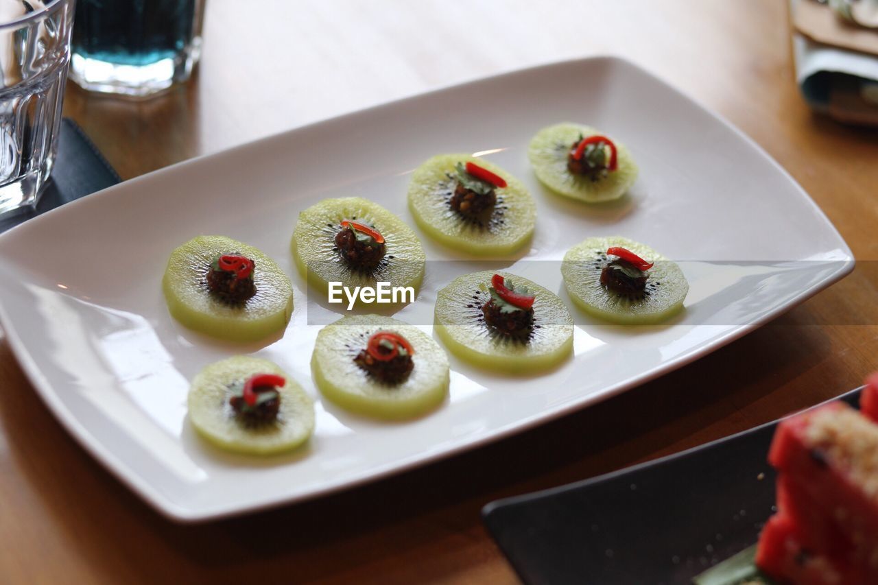 Kiwi fruits in plate on table