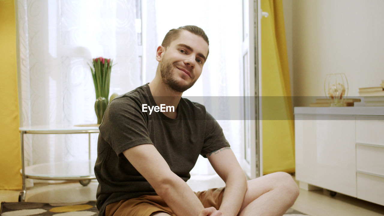 Portrait of young man sitting at home