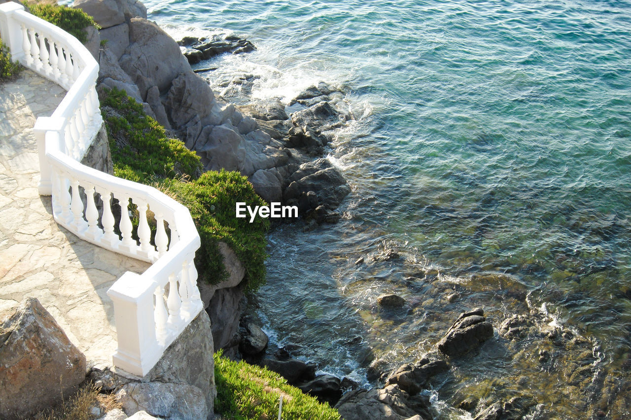 High angle view of rocks by  mediterranean sea waves