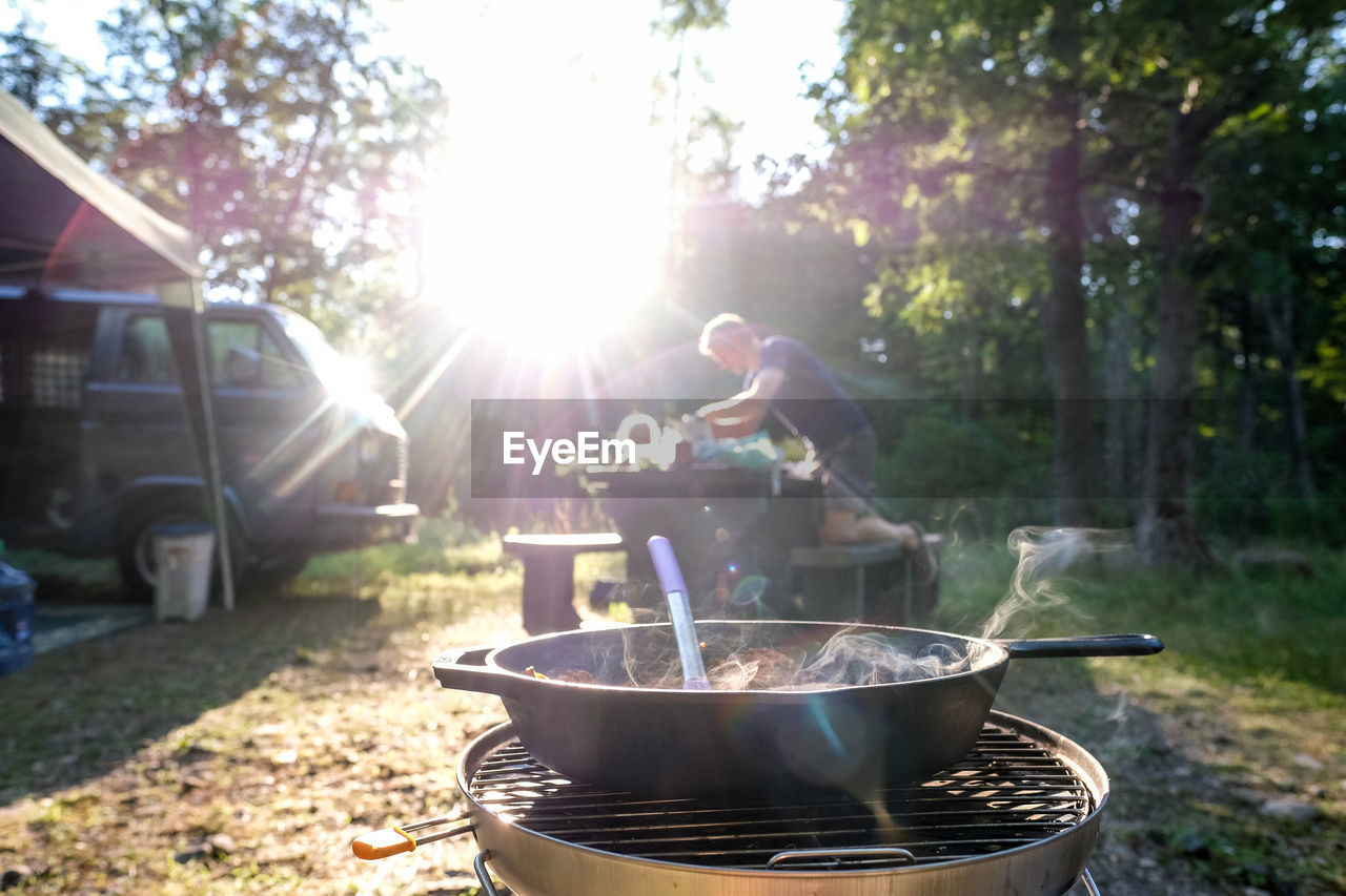 Man setting up dinner at campground food on stove