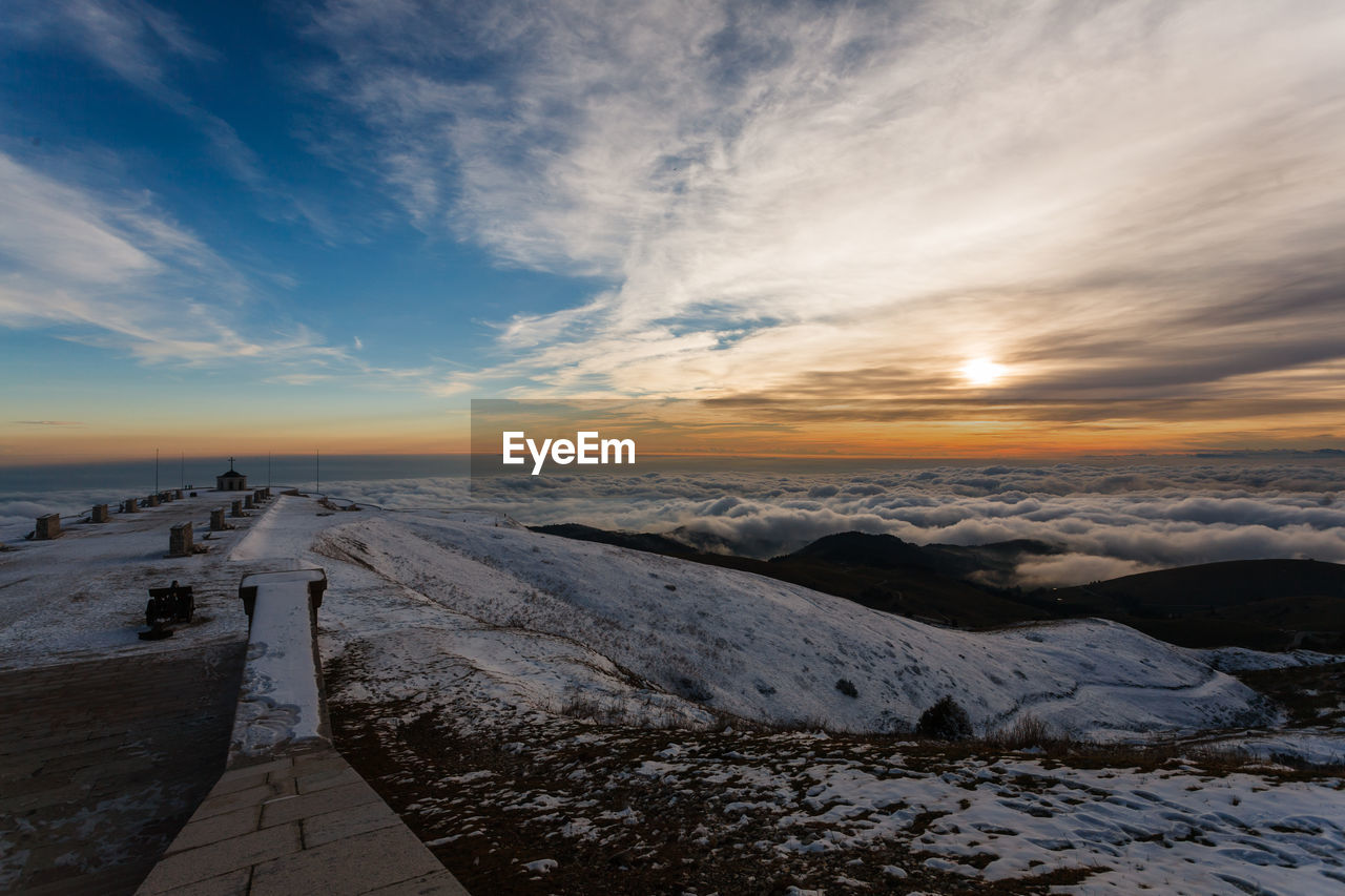 Scenic view of snowcapped mountains against sky during sunset