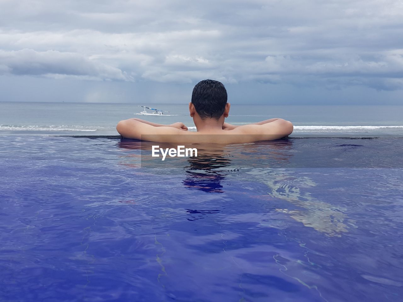 Rear view of shirtless in sea against sky