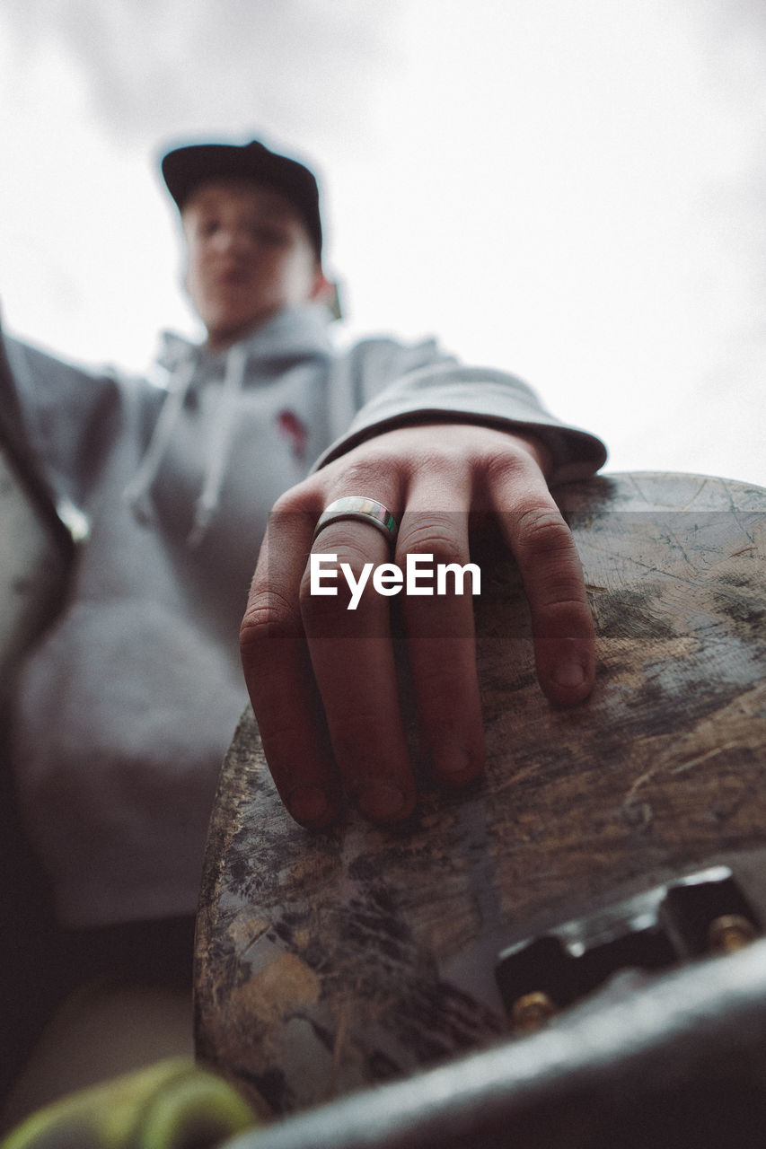 Low angle view of man touching rock