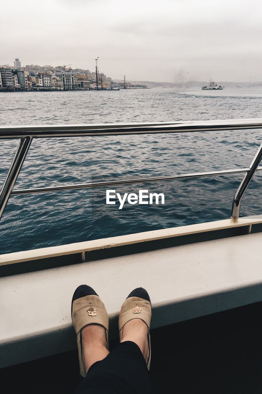 Low section of woman in boat sailing on sea