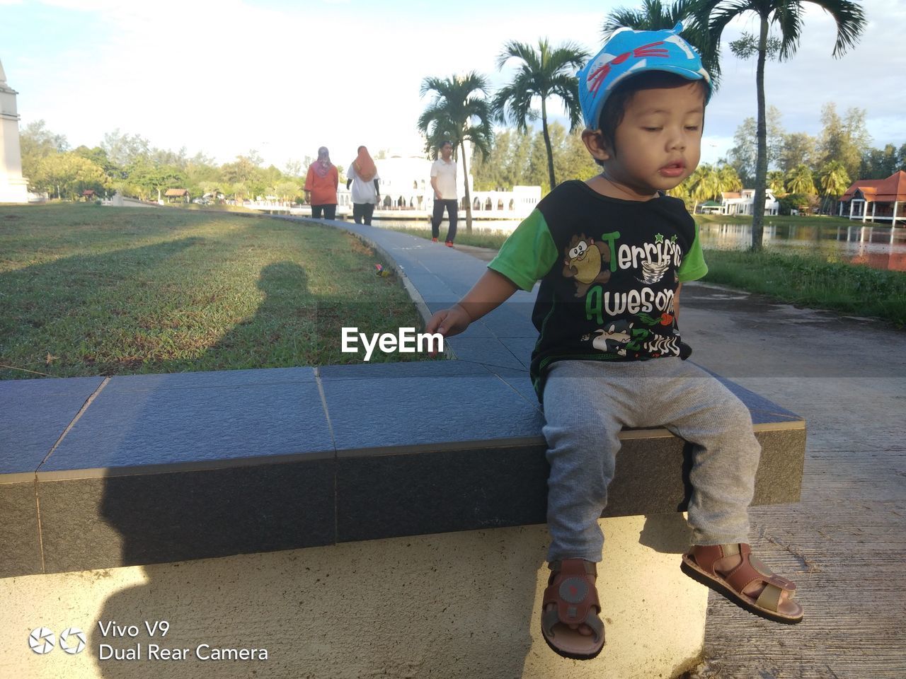 FULL LENGTH OF BOY LOOKING AT CAMERA WHILE SITTING IN BUS