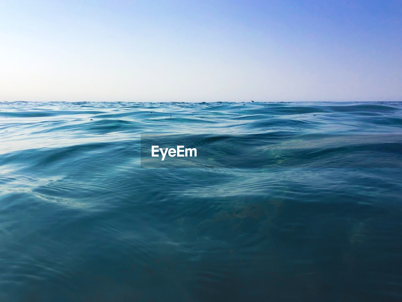 Scenic view of sea against clear blue sky
