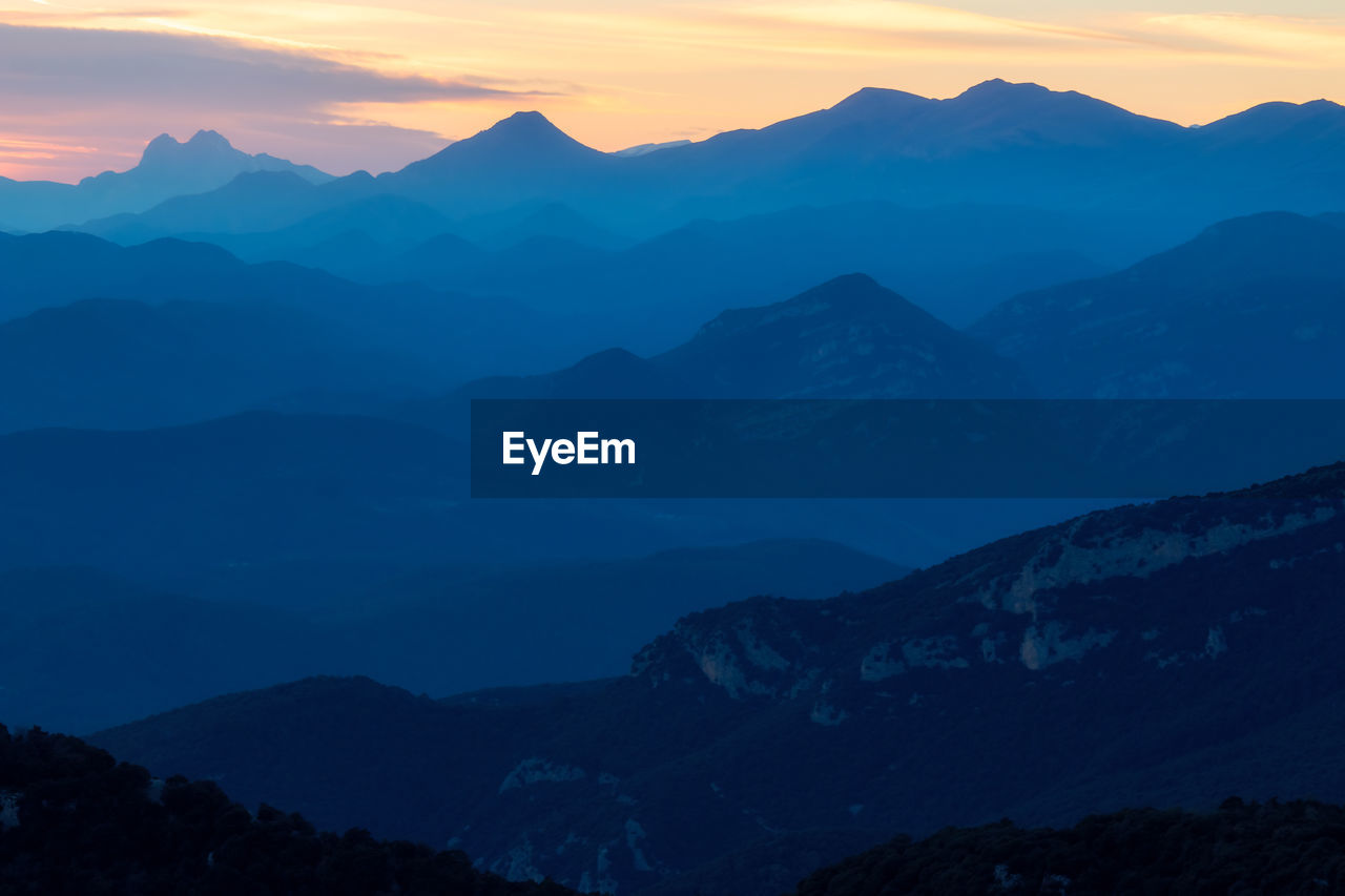 mountain, scenics - nature, environment, mountain range, beauty in nature, landscape, sky, sunset, nature, dawn, twilight, tranquility, land, cloud, tranquil scene, travel, silhouette, sun, mountain peak, travel destinations, no people, outdoors, fog, non-urban scene, idyllic, wilderness, ridge, summit, forest, dramatic sky, valley, tourism, massif, sunlight, blue, activity, awe, tree, plant, cold temperature, winter