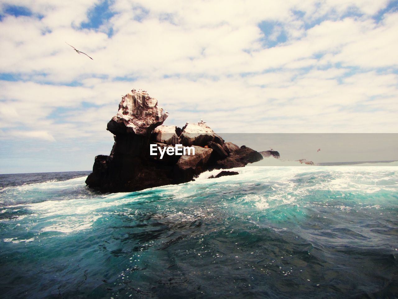 Rock formation in sea against sky