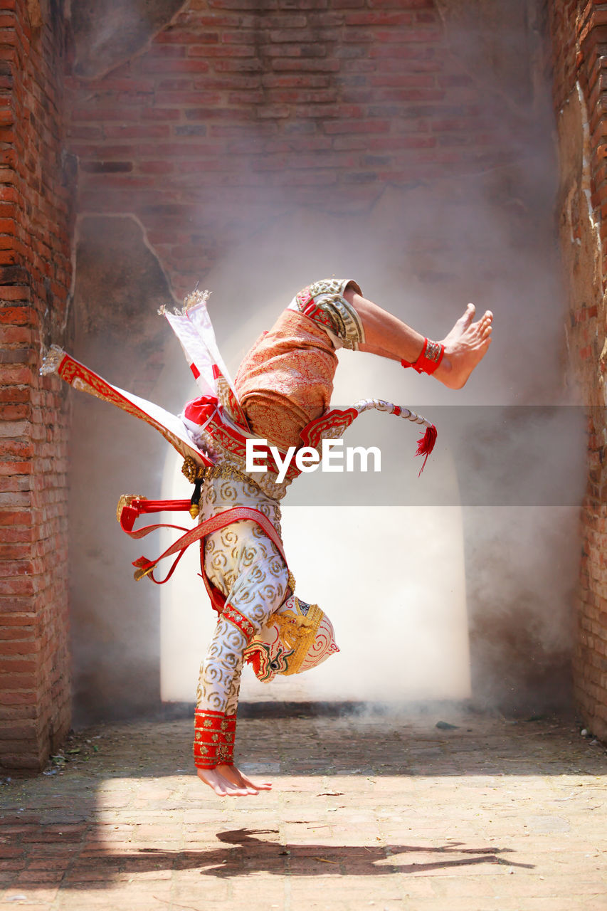 Male dancer wearing traditional clothing while performing on stage