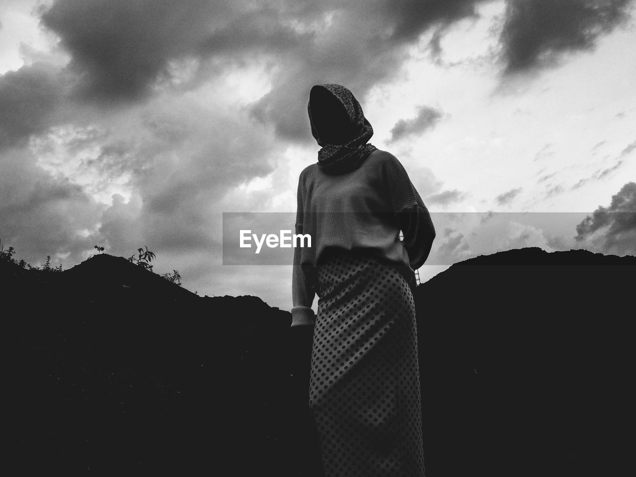 LOW ANGLE VIEW OF MAN STANDING AGAINST SKY