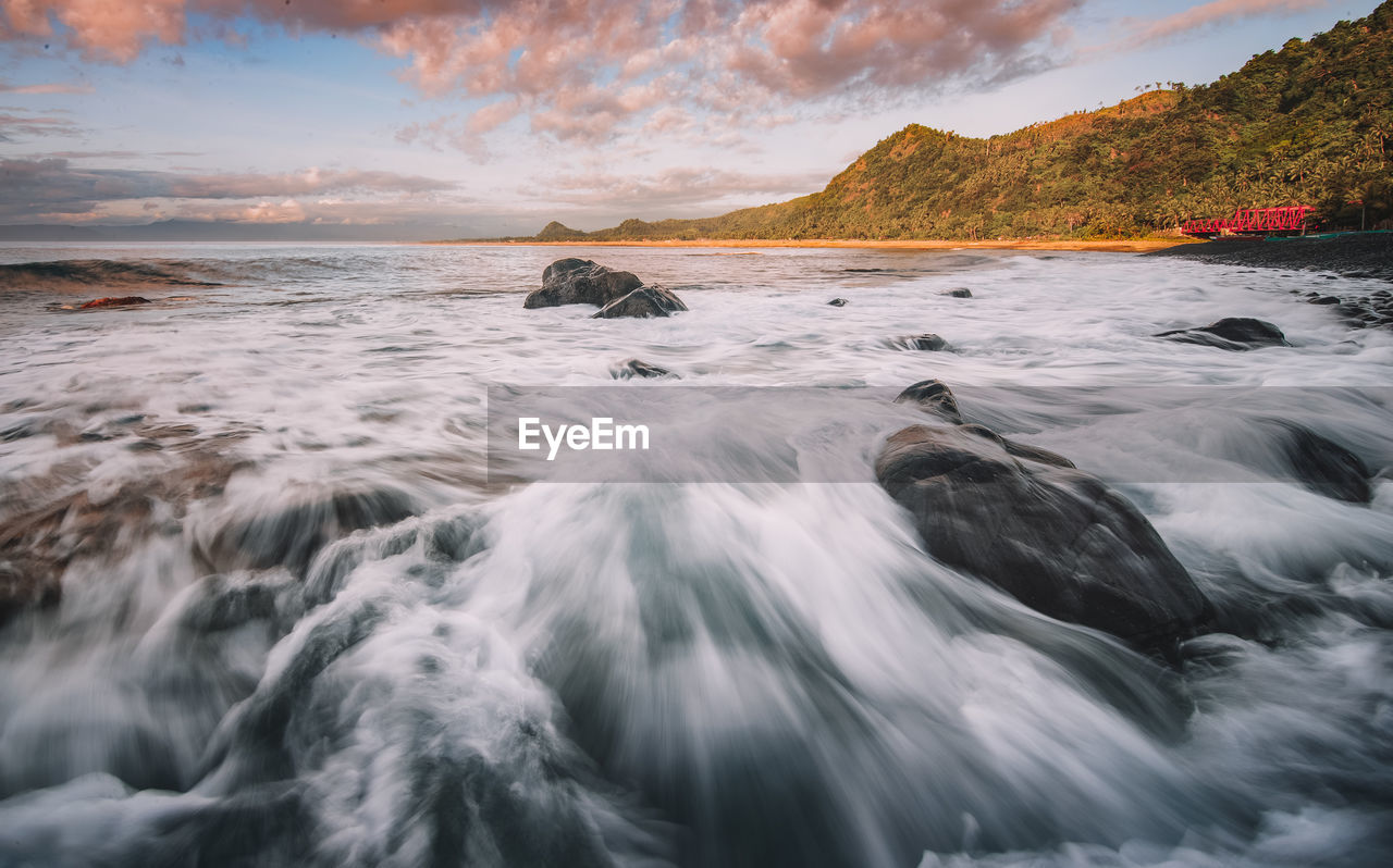 Water flowing in sea against sky