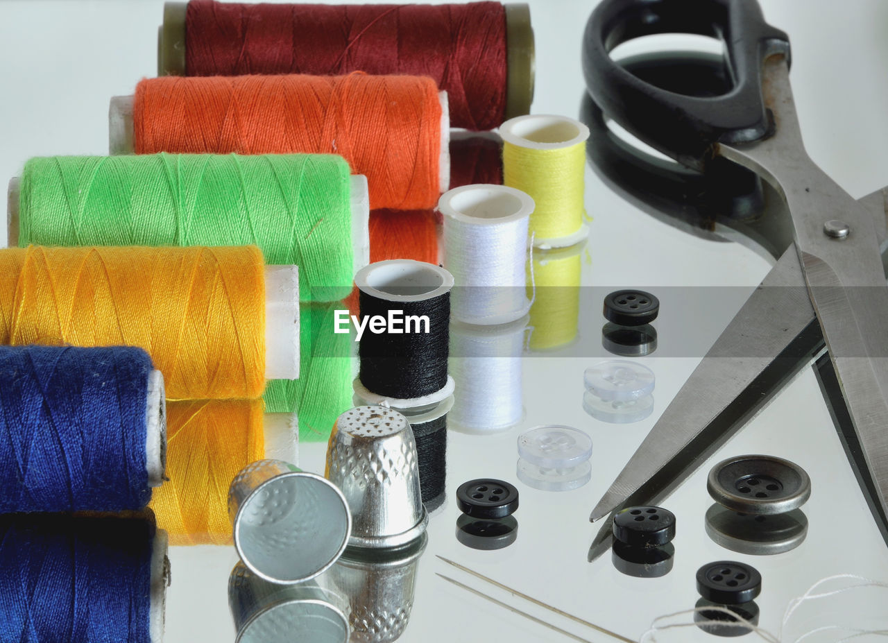 Close-up of sewing items on glass table