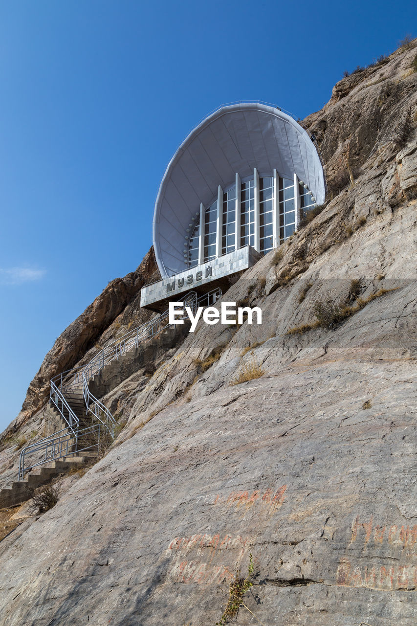 sky, rock, architecture, built structure, nature, travel destinations, travel, no people, landmark, clear sky, blue, day, building exterior, outdoors, mountain, environment, tourism, landscape, sunny