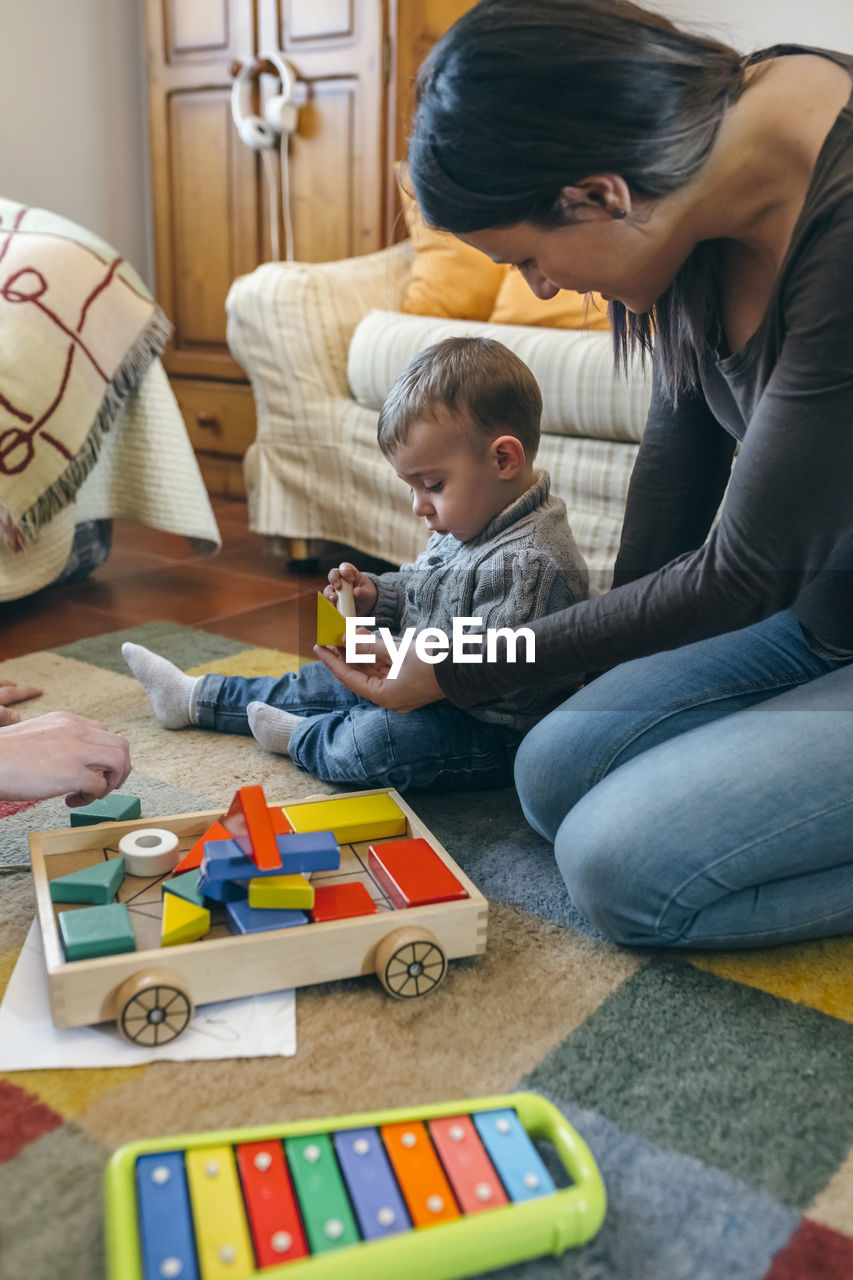 Mother and son playing with toys at home