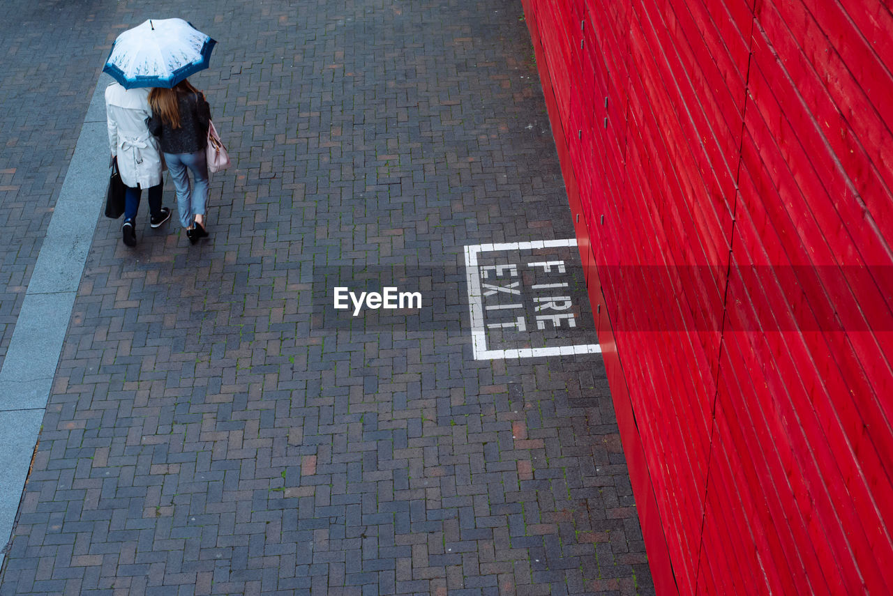 High angle view of sign on cobblestone street in city