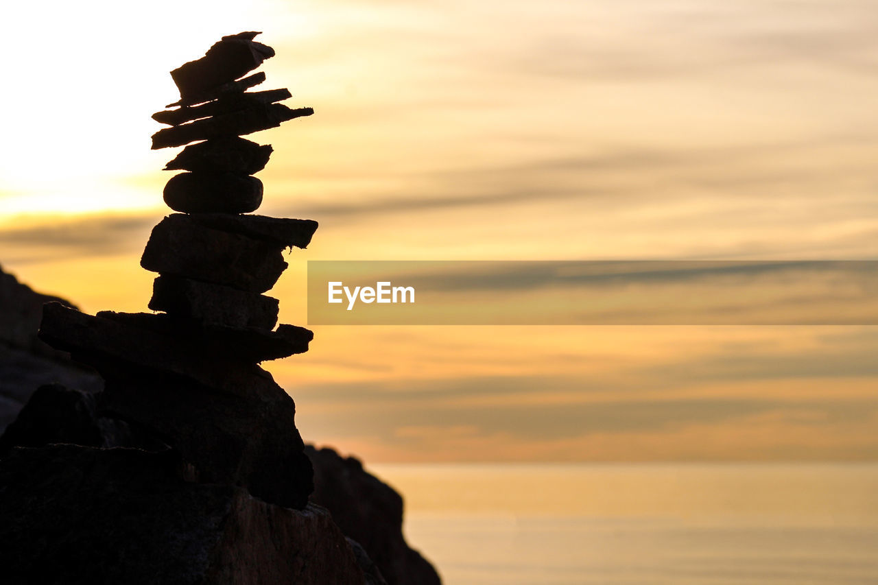 STACK OF ROCKS ON SHORE DURING SUNSET