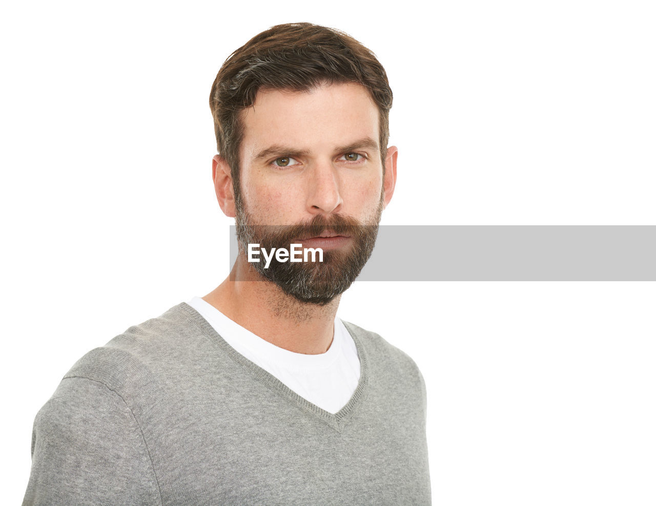 portrait, white background, beard, one person, facial hair, adult, studio shot, human hair, men, casual clothing, cut out, indoors, hairstyle, moustache, looking at camera, young adult, t-shirt, finger, copy space, headshot, clothing, front view, emotion, brown hair, person, relaxation, white, human face, looking, standing, arm, stubble, sleeve