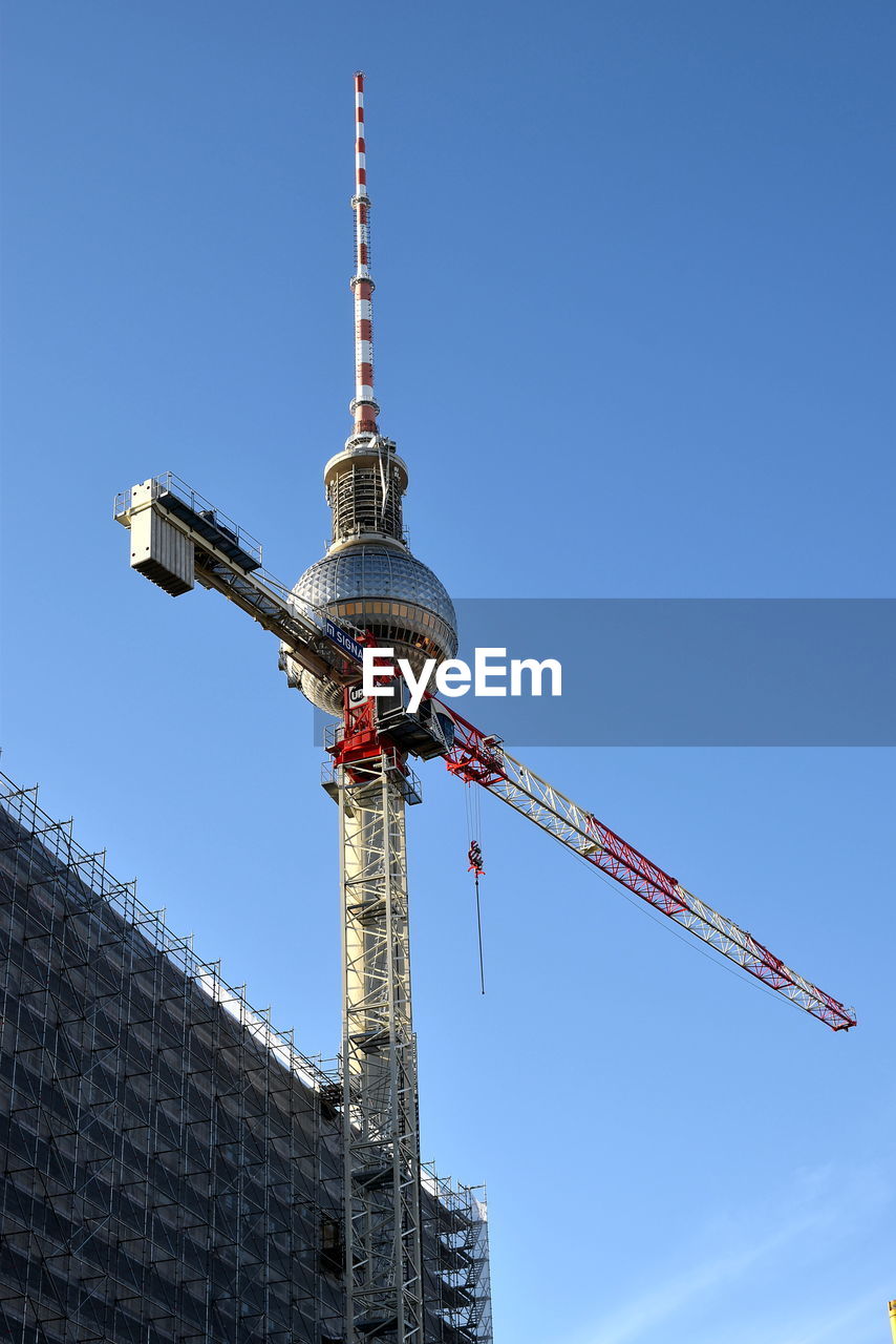 LOW ANGLE VIEW OF CRANE AND BUILDING AGAINST SKY