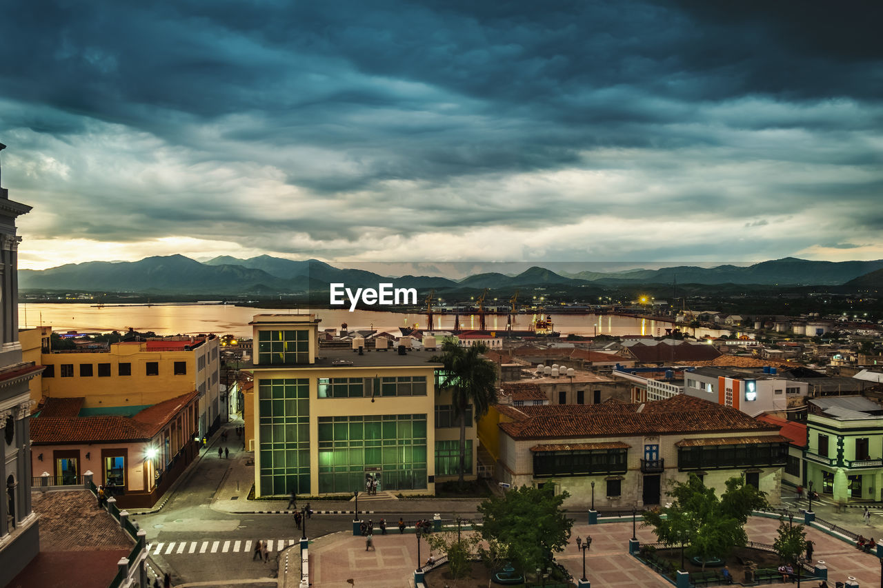 HIGH ANGLE VIEW OF BUILDINGS IN TOWN AGAINST SKY