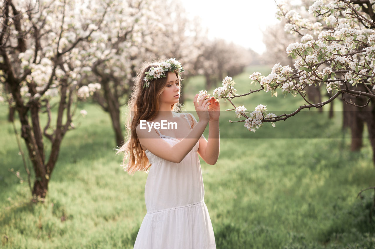 Teenager girl wearing gown standing at park