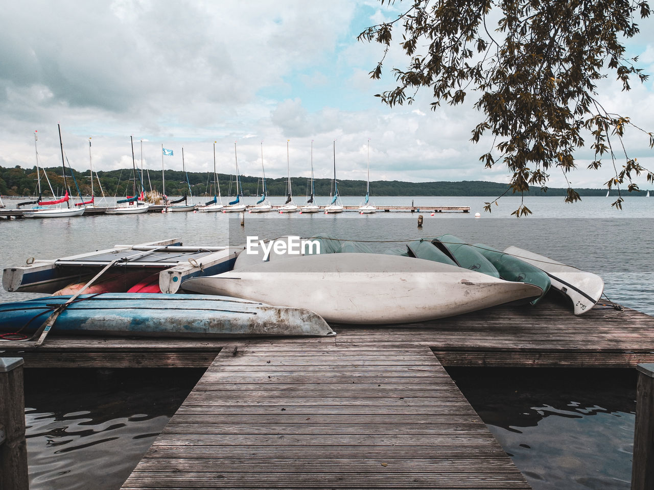 water, dock, nautical vessel, transportation, pier, sky, nature, boat, sea, moored, wood, mode of transportation, vehicle, cloud, marina, shore, tranquility, jetty, day, harbor, no people, boating, beach, beauty in nature, tree, watercraft, travel destinations, land, travel, scenics - nature, tranquil scene, outdoors, architecture, ship, holiday, coast, environment, plant, vacation, trip, idyllic, landscape, bay