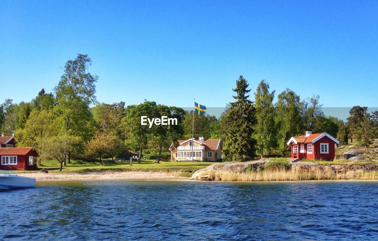 SCENIC VIEW OF RIVER AND HOUSES AGAINST SKY