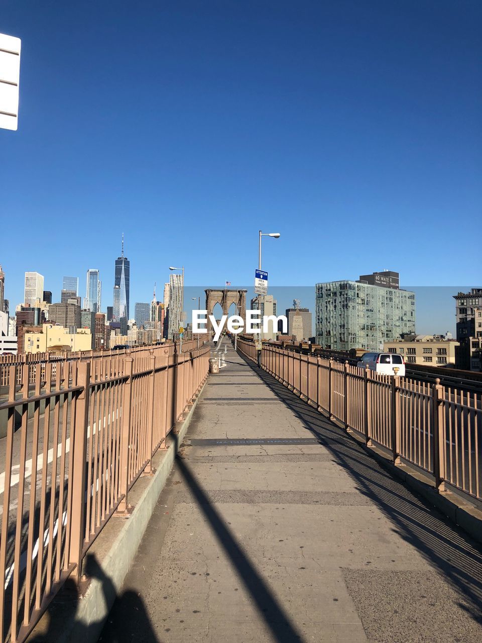 Street amidst buildings against clear blue sky