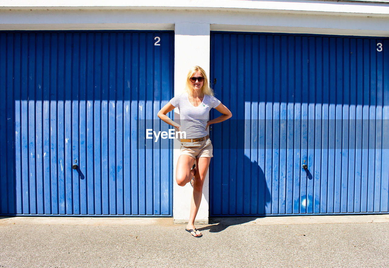 Woman standing against blue wall