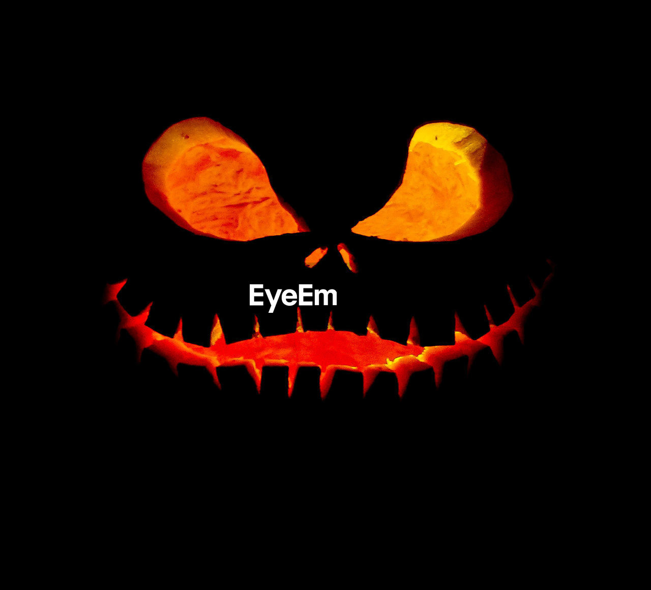 Close-up of illuminated jack o lantern against black background