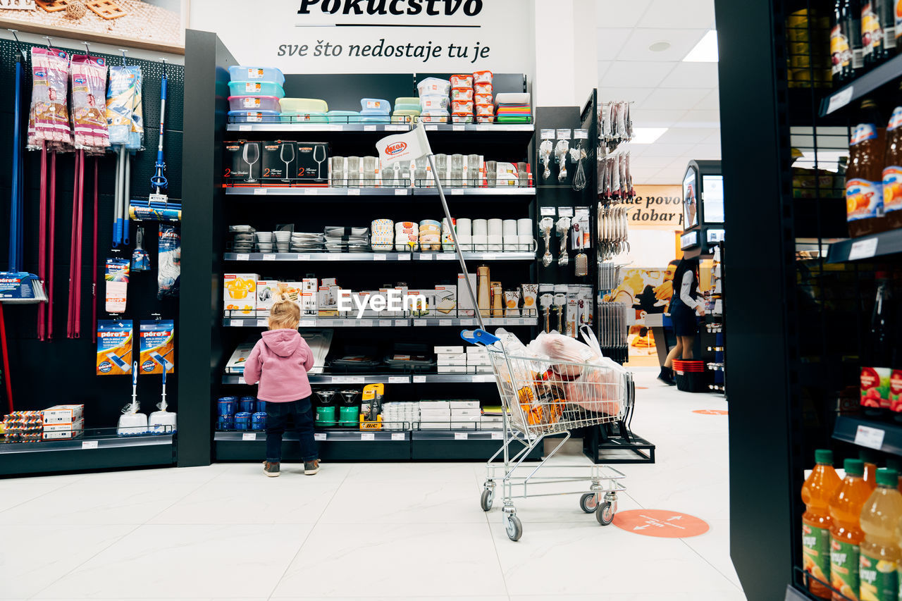 WOMAN STANDING BY STORE